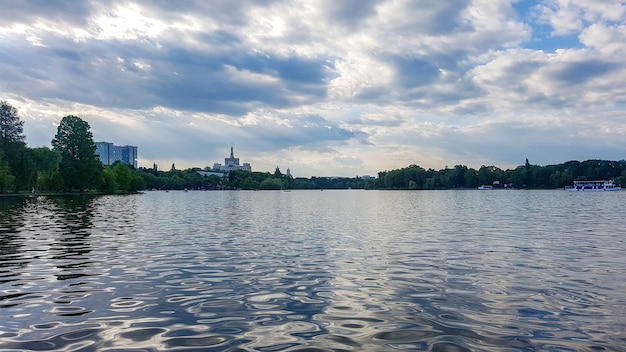 Фото Вид на здания вдоль реки на фоне облачного неба