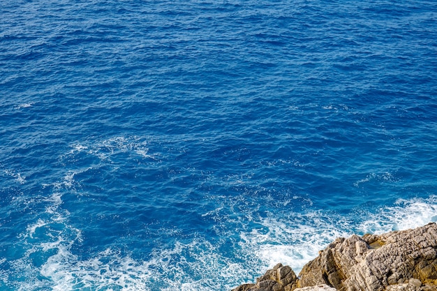 写真 澄んだ青い水と海岸線の岩の眺め