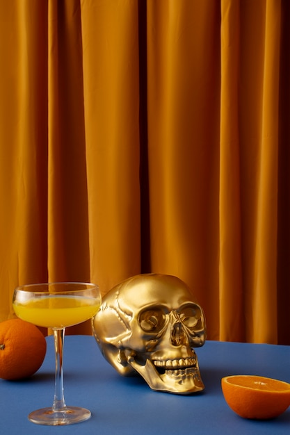 Фото Вид на золотой череп с цитрусовым коктейлем