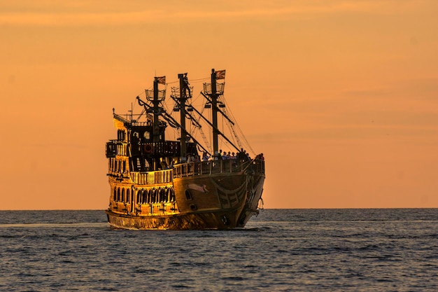 Фото Вид корабля в море на фоне неба во время захода солнца