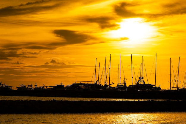 写真 夕日の眺めと湖のヨットのシルエット