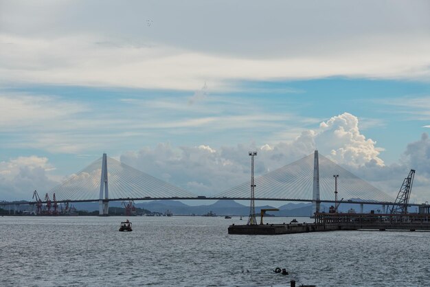 写真 空と対照的に海を越えた吊り橋の景色