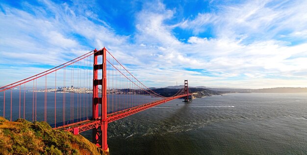 写真 雲の空を背景に吊るされたゴールデン・ゲート・ブリッジの景色