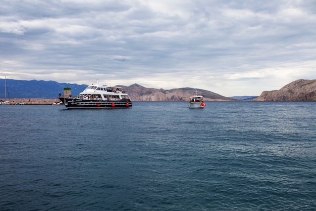 Фото Вид на море, горы и корабль в пасмурную погоду.