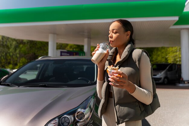 写真 ガソリンスタンドで車を持つ女性の眺め