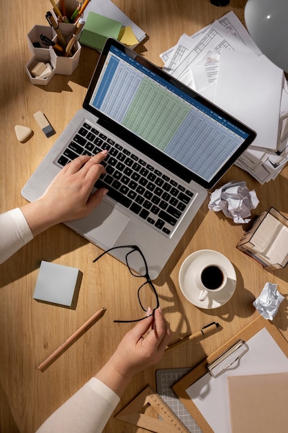 Foto vista della scrivania dell'ufficio con un'area di lavoro disordinata e un computer portatile