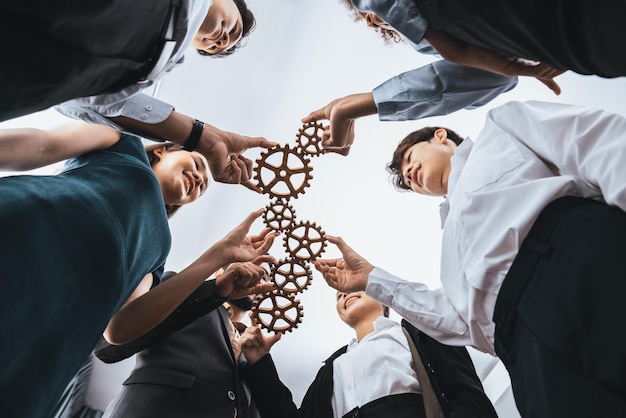 Below view office worker holding cog wheel as unity and teamwork in corporate workplace concept Diverse colleague business people as symbol of visionary system teamwork for business success Concord