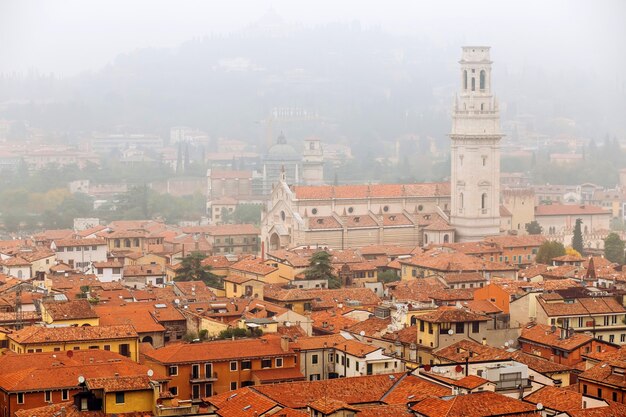 航空写真ビュー、イタリアのヴェローナ旧市街を表示します。ヴェローナの上の霧。イタリアの中世都市の赤い屋根