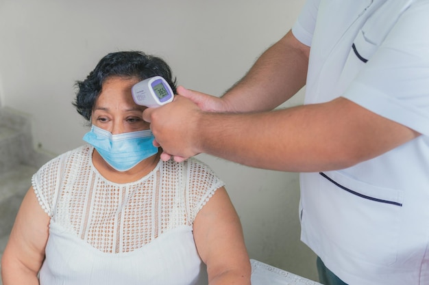 View of an older woman checking the temperature with a digital thermometer