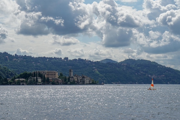 View of orta lake with san giulio island with sail boat