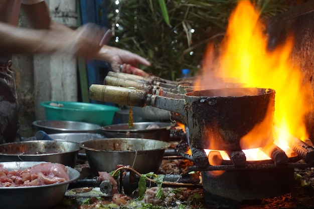 Photo view of person cooking on fire outdoors