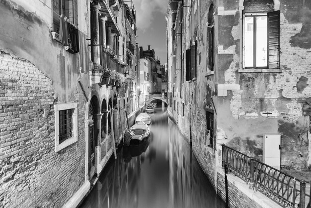 View over a picturesque canal and little bridge at night in Santa Croce district of Venice, Italy