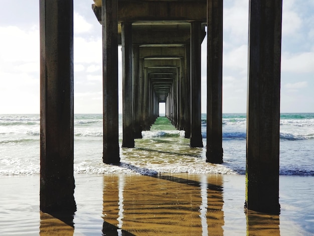 Photo below view pier over sea against sky