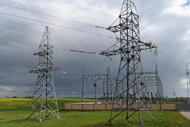 Foto vista della centrale elettrica e dei tralicci di trasmissione in una giornata nuvolosa polo elettrico ad alta tensione e linee di trasmissione