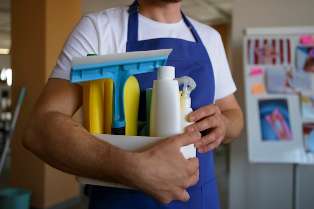 View of professional cleaning service person holding supplies