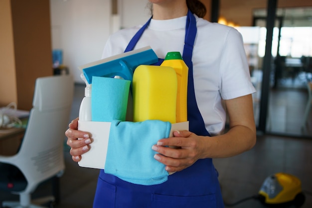 Photo view of professional cleaning service person holding supplies