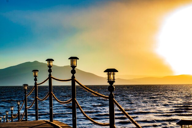 View of railing in sea during sunset