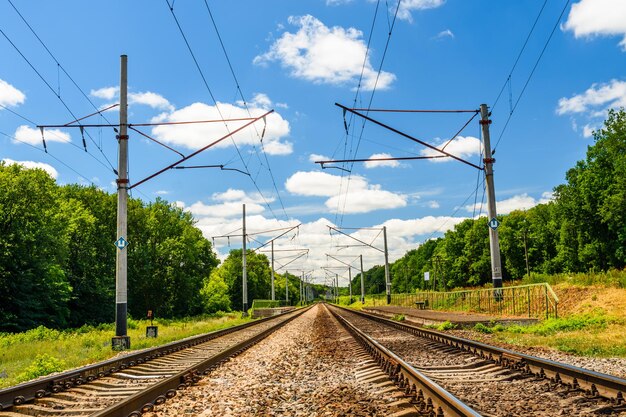 View on a railroad track and white clouds in a blue sky