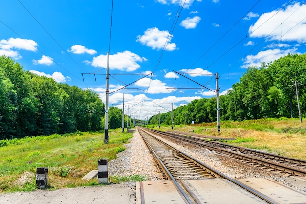 View on a railroad track and white clouds in a blue sky