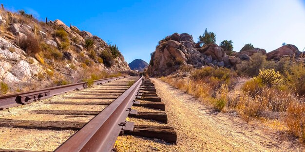 Foto vista dei binari della ferrovia contro un cielo blu limpido