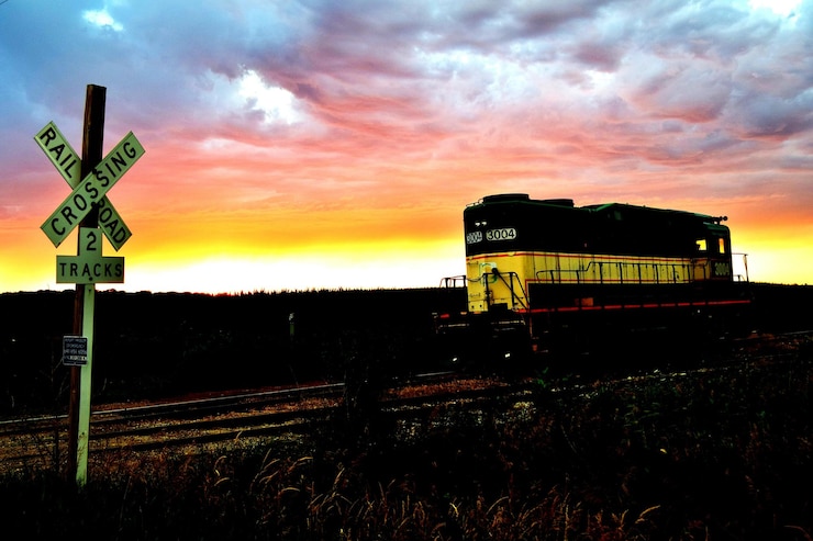 Photo view of railroad tracks against sunset sky