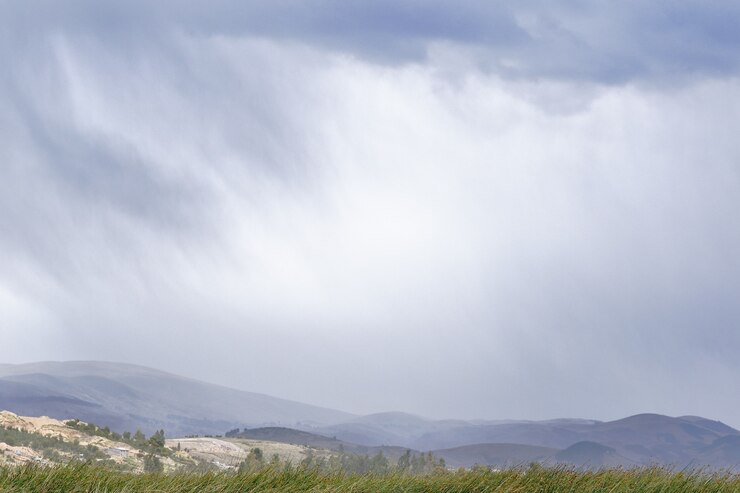 Photo view of the rain falling in the distance on the horizon over the andean mountains