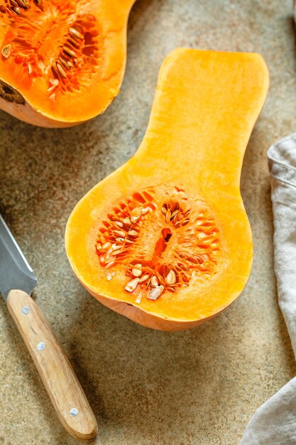 View on raw halves of butternut squash on a kitchen table Seasonal vegetable food still life