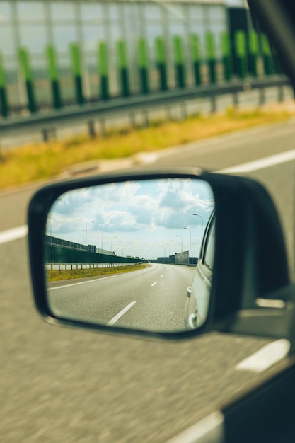 View in rear mirror of the car road trip