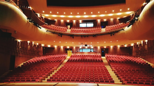 Photo view of red chairs in auditorium