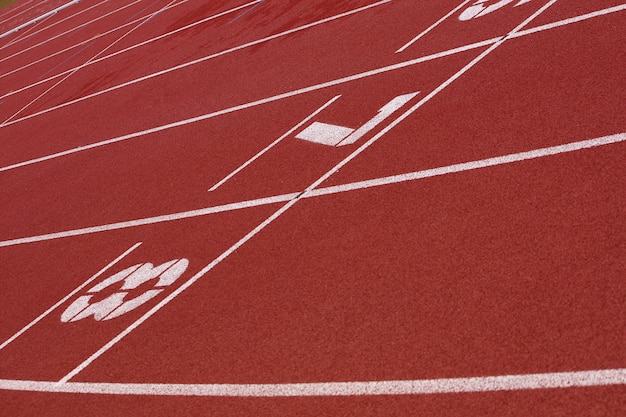 View of a red tartan athletic running track with white numbers. 