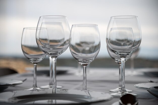 식당 의 테이블 에서 와인 잔 과 식사객 들 에게 제공 되는 접시 를 볼 수 있다
