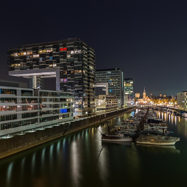 Photo a view of the rhineau harbour with crane houses at night in germany. taken outside with a 5d mark iii.