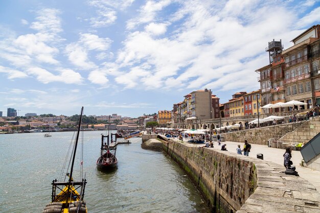 Foto vista del molo ribeira nella città di porto in una giornata di sole con un cielo blu