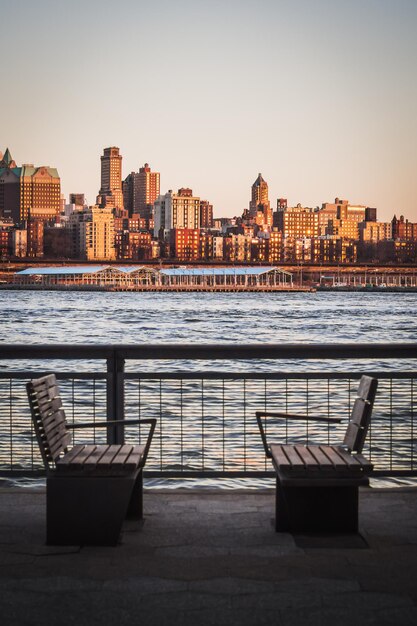 Photo view of river and buildings against sky during sunset