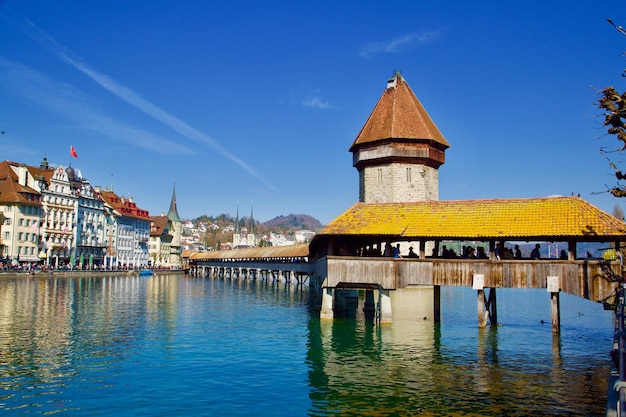 View of river by buildings against blue sky