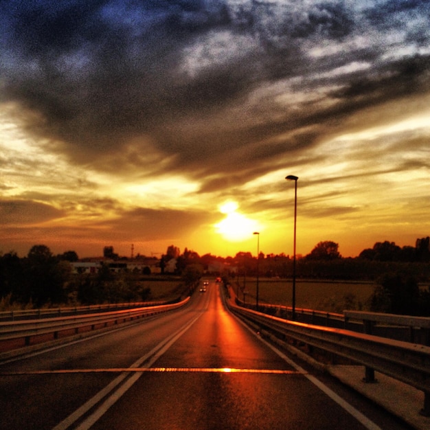 Foto vista della strada contro il cielo nuvoloso al tramonto