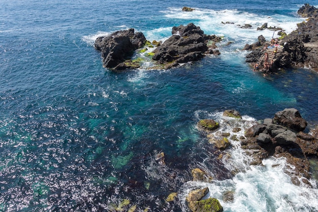 高いところから岩と海を眺める