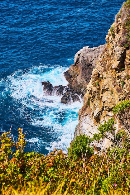 View of rocky cliffs being hit by ocean waves from above