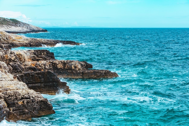 View of rocky seaside waves with white foam