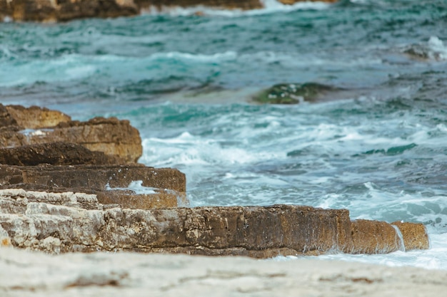 View of rocky seaside waves with white foam