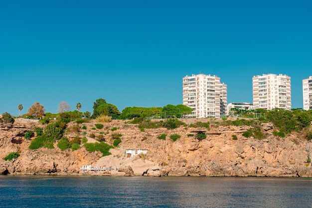 Photo view of the rocky shore with highrise buildings in the city of antalya