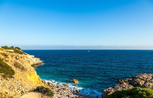 View of the rocky wild beach with people