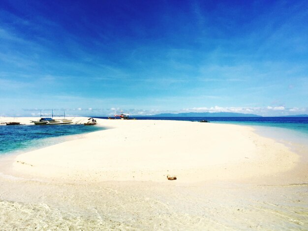 View of sand at beach against blue sky