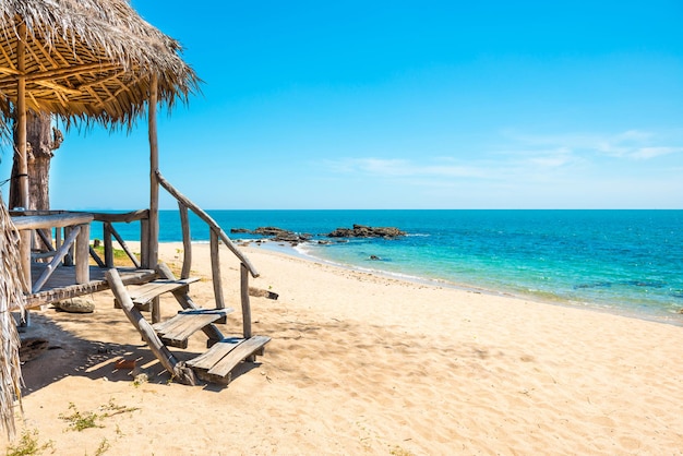 View of sand beach, sea, blue sky and hut at tropical island