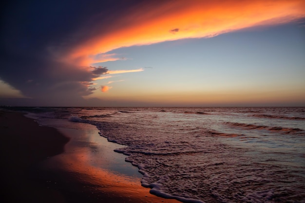 View of the sandy beach during a dramatic cloudy sunset