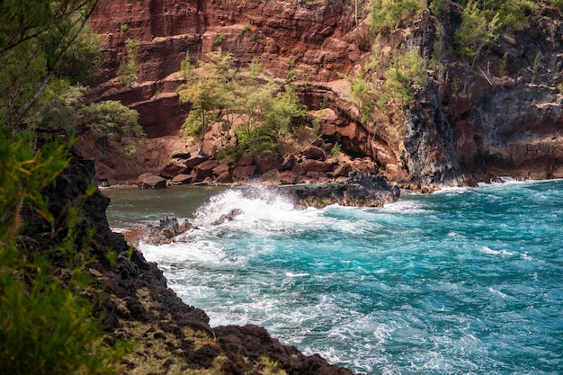 View of sea beach with waves and rocky coast. Red Sand Beach, Maui in in Hawaiian.