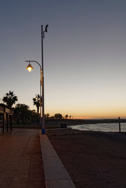 Vista sul mare e lampione sulla spiaggia di pedregalejo al tramonto.