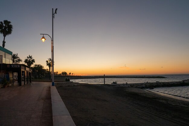 View of the sea and Lamppost on the Pedregalejo Beach at dusk.