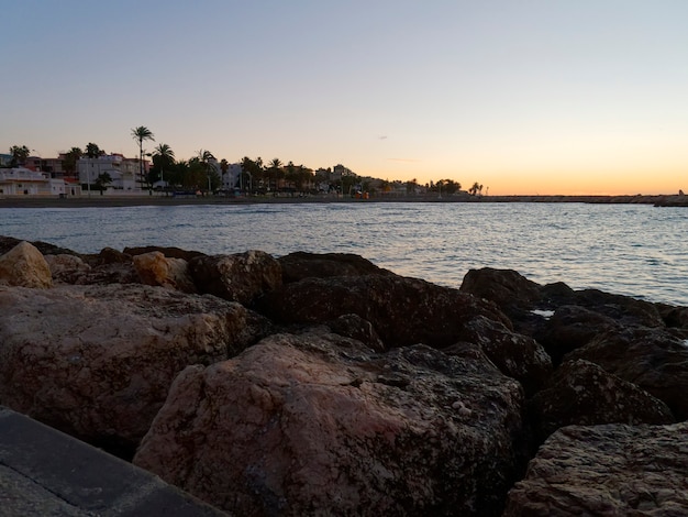 View of the sea and stones on the Pedregalejo Beach at dusk.