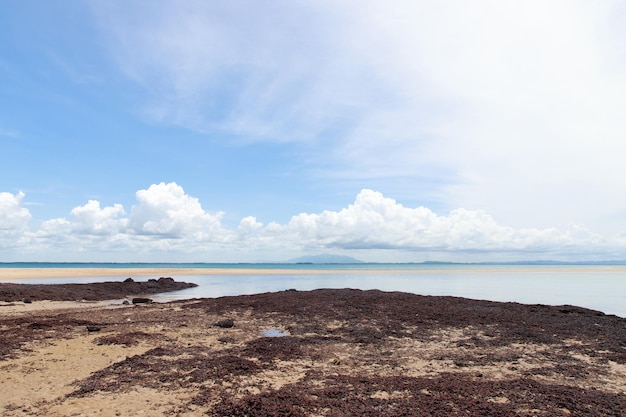 View of sea waves shore and fantastic rocky beach coast on the island and background sky with mountain Wild nature Tropical landscape coastline Summertime Travel holiday concept